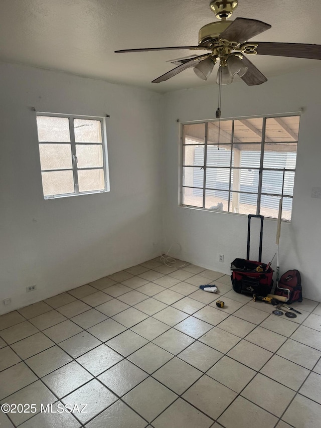 unfurnished room featuring plenty of natural light, a ceiling fan, and light tile patterned floors