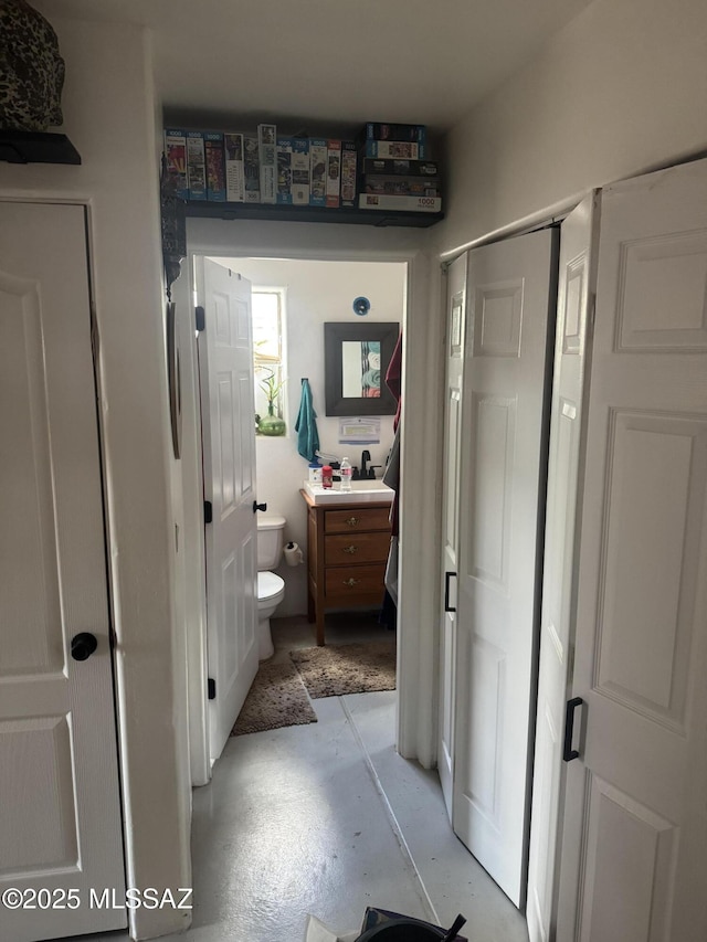 bathroom featuring vanity, toilet, and concrete floors