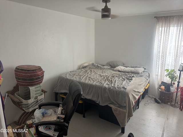 bedroom with concrete floors and a ceiling fan