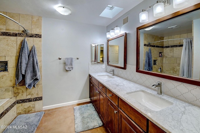 6631 N Camino Padre Isidoro, Tucson, AZ 85718 - bathroom with a skylight, a tile shower, double vanity, tasteful backsplash, and baseboards