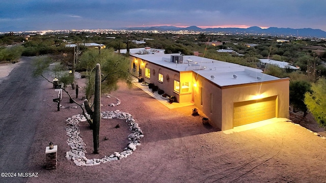 6631 N Camino Padre Isidoro, Tucson, AZ 85718 - view of front of home with an attached garage, a mountain view, stucco siding, and dirt driveway