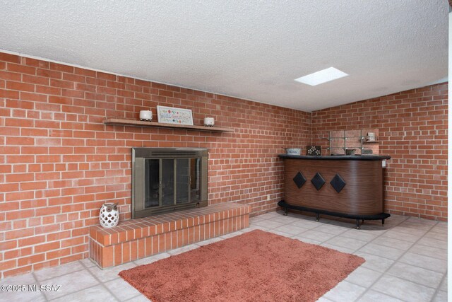 2702 E Prince Rd, Tucson, AZ 85716 - living area featuring a textured ceiling, vaulted ceiling, a brick fireplace, and tile patterned flooring