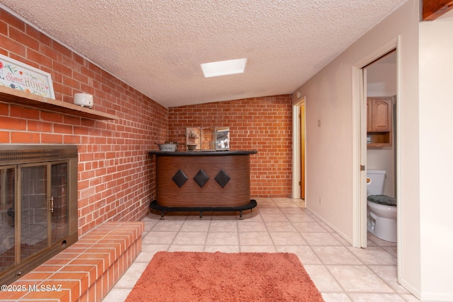 2702 E Prince Rd, Tucson, AZ 85716 - detailed view of a glass covered fireplace, brick wall, and a textured ceiling