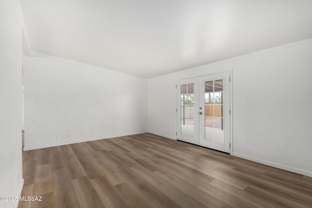 7433 E 19th St, Tucson, AZ 85710 - empty room featuring french doors, wood finished floors, and baseboards