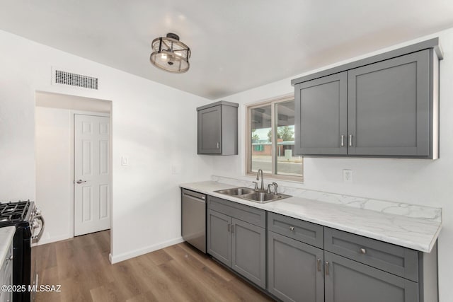 7433 E 19th St, Tucson, AZ 85710 - kitchen with a sink, gray cabinets, stainless steel appliances, wood finished floors, and baseboards