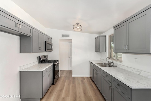 7433 E 19th St, Tucson, AZ 85710 - kitchen with stainless steel appliances, a sink, gray cabinetry, and light countertops