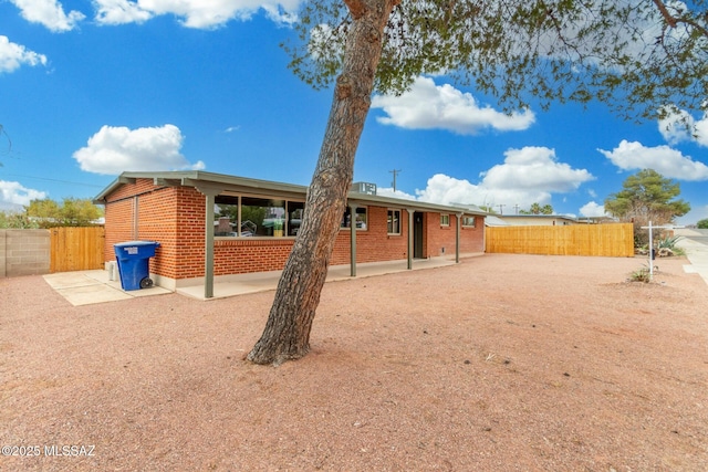 7433 E 19th St, Tucson, AZ 85710 - back of house featuring brick siding and a patio area