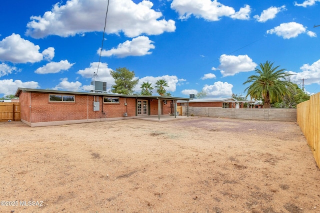 7433 E 19th St, Tucson, AZ 85710 - back of property with brick siding, french doors, a fenced backyard, and a patio