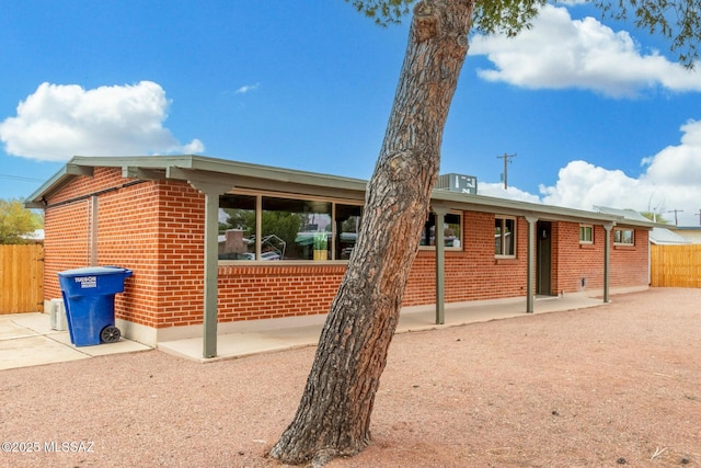 7433 E 19th St, Tucson, AZ 85710 - back of house with brick siding, a patio area, and central air condition unit