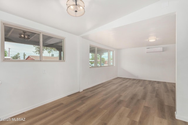 7433 E 19th St, Tucson, AZ 85710 - empty room with an AC wall unit, wood finished floors, and baseboards