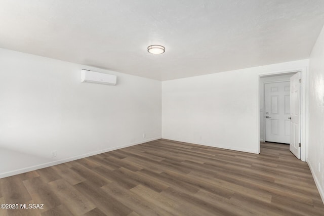 7433 E 19th St, Tucson, AZ 85710 - spare room featuring an AC wall unit, wood finished floors, and baseboards