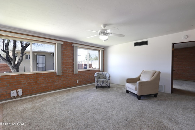 3010 E Sylvia St, Tucson, AZ 85716 - sitting room featuring ceiling fan, carpet flooring, and brick wall
