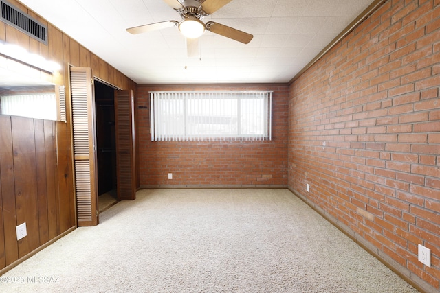 3010 E Sylvia St, Tucson, AZ 85716 - unfurnished bedroom with carpet flooring, brick wall, wood walls, and a closet