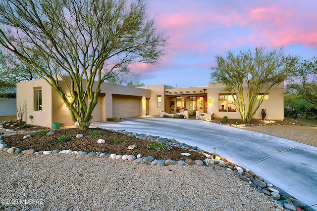 2500 N Fennimore Ave, Tucson, AZ 85749 - pueblo-style home featuring concrete driveway, stucco siding, and an attached garage