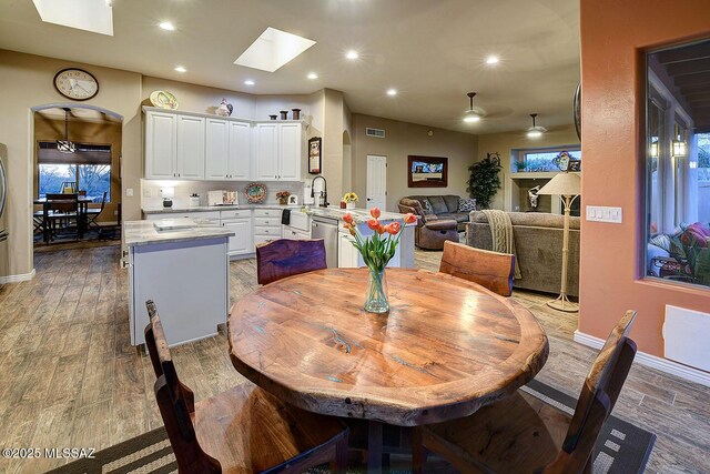 2500 N Fennimore Ave, Tucson, AZ 85749 - dining space featuring a skylight, light wood-type flooring, recessed lighting, a ceiling fan, and baseboards