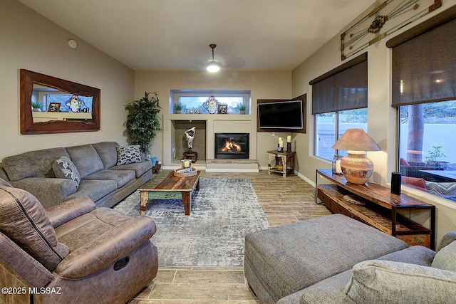 2500 N Fennimore Ave, Tucson, AZ 85749 - living area featuring ceiling fan, a glass covered fireplace, light wood-type flooring, and baseboards