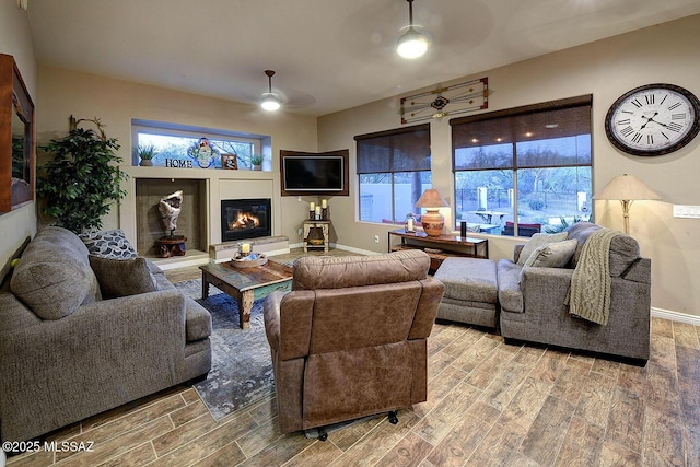 2500 N Fennimore Ave, Tucson, AZ 85749 - living area with ceiling fan, a glass covered fireplace, wood finished floors, and plenty of natural light
