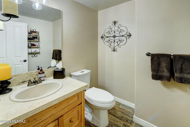 2500 N Fennimore Ave, Tucson, AZ 85749 - half bath featuring toilet, vanity, wood finished floors, and baseboards