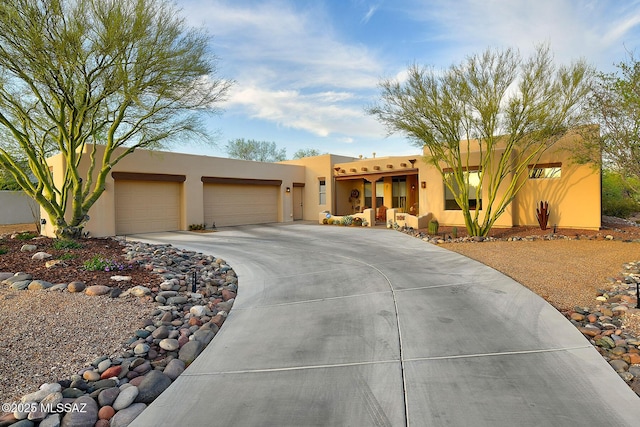2500 N Fennimore Ave, Tucson, AZ 85749 - pueblo revival-style home featuring an attached garage, concrete driveway, and stucco siding