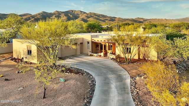 2500 N Fennimore Ave, Tucson, AZ 85749 - pueblo-style home featuring concrete driveway, a mountain view, an attached garage, and stucco siding