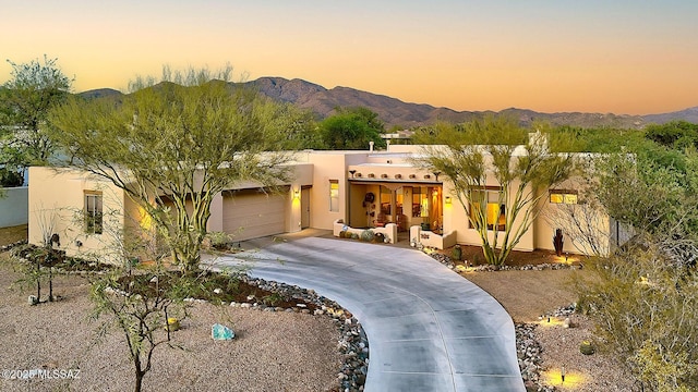 2500 N Fennimore Ave, Tucson, AZ 85749 - pueblo revival-style home featuring driveway, an attached garage, stucco siding, and a mountain view
