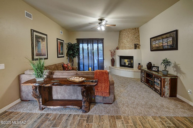2500 N Fennimore Ave, Tucson, AZ 85749 - living room with wood tiled floors, a ceiling fan, a fireplace, and baseboards