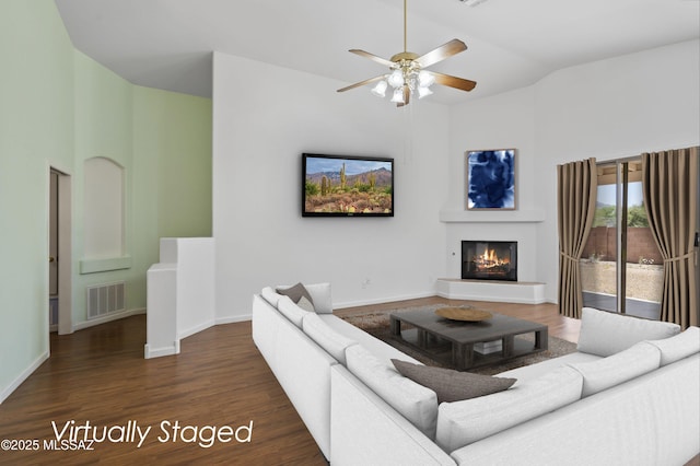 9488 N Elan Ln, Tucson, AZ 85742 - living room with high vaulted ceiling, a glass covered fireplace, ceiling fan, wood finished floors, and baseboards