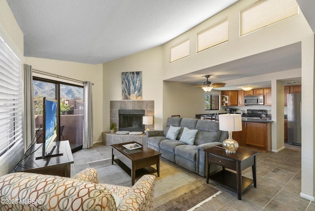 5051 N Sabino Canyon Rd Unit 2162, Tucson, AZ 85750 - living room featuring plenty of natural light, a tiled fireplace, and a ceiling fan