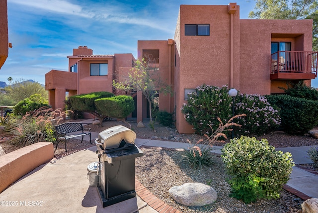 5051 N Sabino Canyon Rd Unit 2162, Tucson, AZ 85750 - view of front of house featuring a balcony, stucco siding, a patio area, and a chimney