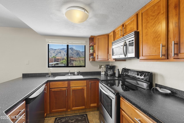 5051 N Sabino Canyon Rd Unit 2162, Tucson, AZ 85750 - kitchen featuring stainless steel appliances, a sink, dark countertops, brown cabinetry, and a textured ceiling