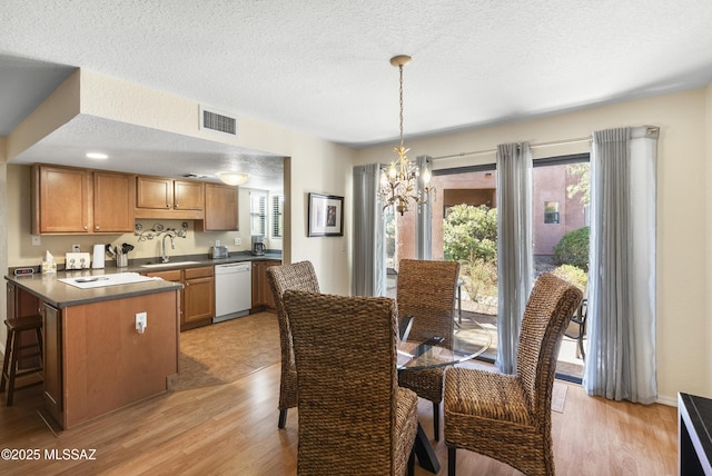 5051 N Sabino Canyon Rd Unit 1107, Tucson, AZ 85750 - dining space with a chandelier, light wood-style floors, and a textured ceiling