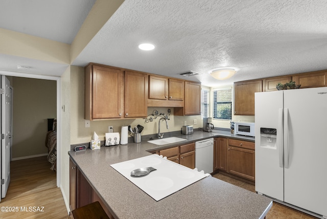 5051 N Sabino Canyon Rd Unit 1107, Tucson, AZ 85750 - kitchen with white appliances, a sink, dark countertops, a textured ceiling, and brown cabinets