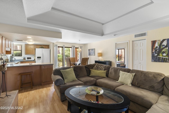 5051 N Sabino Canyon Rd Unit 1107, Tucson, AZ 85750 - living room featuring a raised ceiling and light wood finished floors