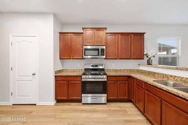 11358 W Folsom Point Dr, Marana, AZ 85658 - kitchen with stainless steel appliances, light wood-type flooring, and light stone counters