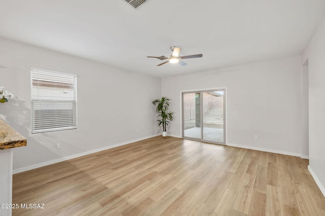 11358 W Folsom Point Dr, Marana, AZ 85658 - spare room featuring plenty of natural light, a ceiling fan, light wood-style flooring, and baseboards