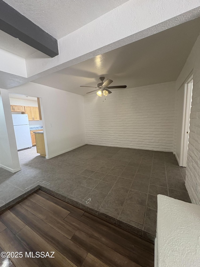 1166 Zircon Ct, Rio Rico, AZ 85648 - spare room with ceiling fan, brick wall, baseboards, and dark wood-type flooring