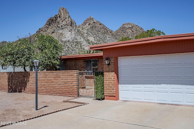 3090 W Alaska St, Tucson, AZ 85746 - view of front of property featuring concrete driveway, a mountain view, a gate, a garage, and brick siding