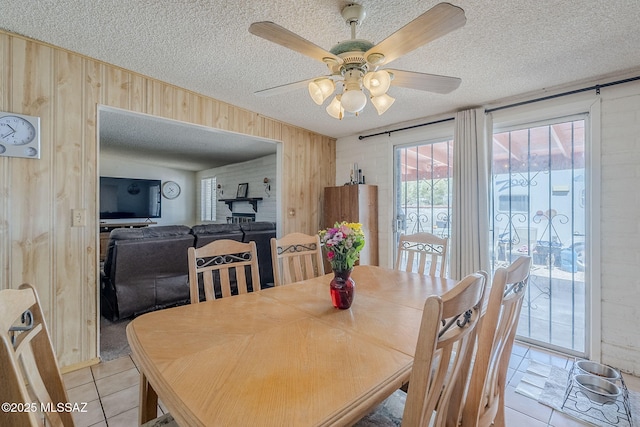 3090 W Alaska St, Tucson, AZ 85746 - dining area with wood walls, light tile patterned floors, a textured ceiling, and a ceiling fan