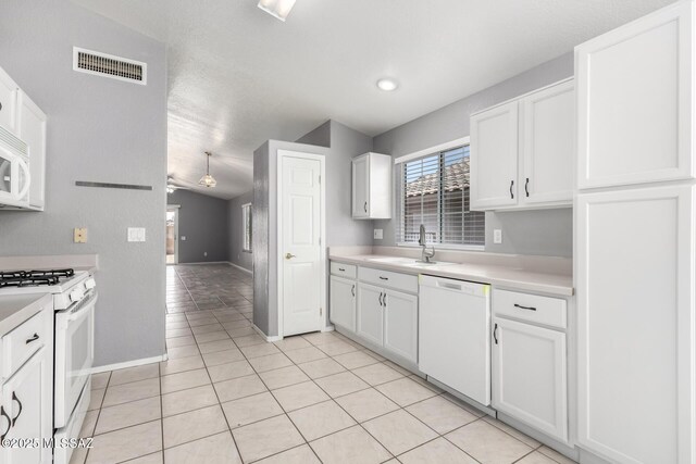 2649 W Catalina View Dr, Tucson, AZ 85742 - kitchen featuring white appliances, a sink, white cabinets, light countertops, and light tile patterned flooring