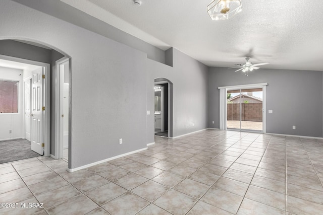 2649 W Catalina View Dr, Tucson, AZ 85742 - spare room with arched walkways, a ceiling fan, light tile patterned flooring, baseboards, and a textured ceiling