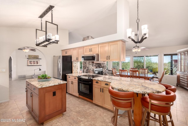 3740 W Placita Fantasia, Tucson, AZ 85745 - kitchen with stainless steel appliances, a chandelier, light brown cabinets, backsplash, and a center island