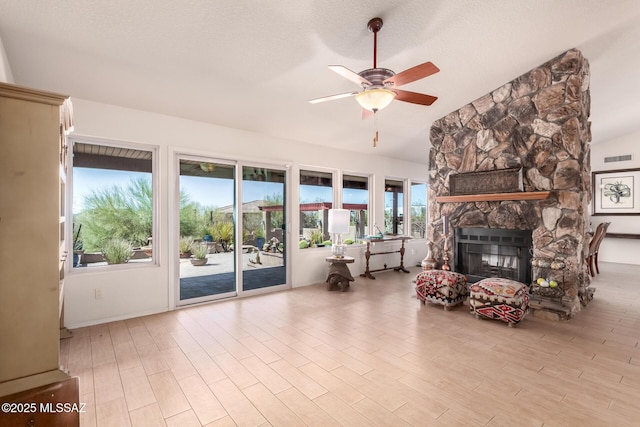 3740 W Placita Fantasia, Tucson, AZ 85745 - living area featuring ceiling fan, lofted ceiling, a stone fireplace, and wood finished floors