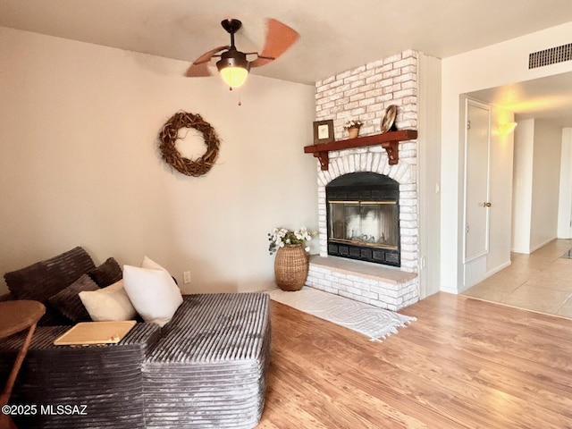 9756 E 32nd St, Tucson, AZ 85748 - living room with a brick fireplace, a ceiling fan, and wood finished floors