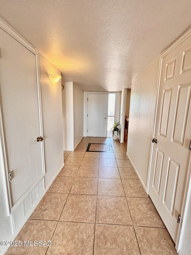 9756 E 32nd St, Tucson, AZ 85748 - hallway with a textured ceiling, light tile patterned floors, and baseboards