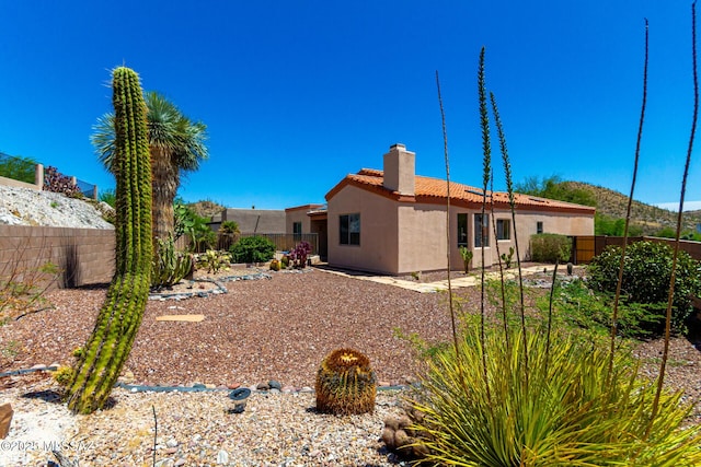 3252 W Flowering Cactus Ct, Tucson, AZ 85745 - back of house with stucco siding, a chimney, a tiled roof, and a fenced backyard