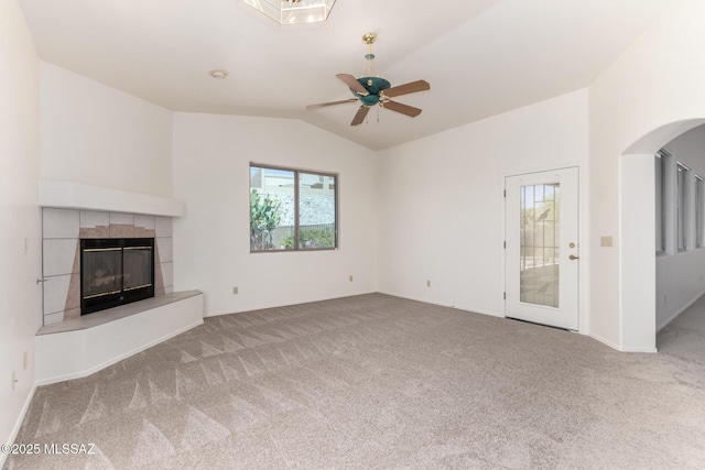 3252 W Flowering Cactus Ct, Tucson, AZ 85745 - unfurnished living room with vaulted ceiling, carpet, a tile fireplace, a ceiling fan, and arched walkways