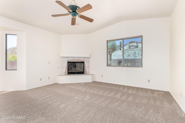 3252 W Flowering Cactus Ct, Tucson, AZ 85745 - unfurnished living room with healthy amount of natural light, carpet floors, lofted ceiling, a tile fireplace, and ceiling fan