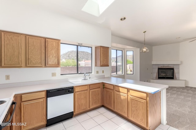3252 W Flowering Cactus Ct, Tucson, AZ 85745 - kitchen with dishwasher, a sink, a tile fireplace, a peninsula, and a skylight