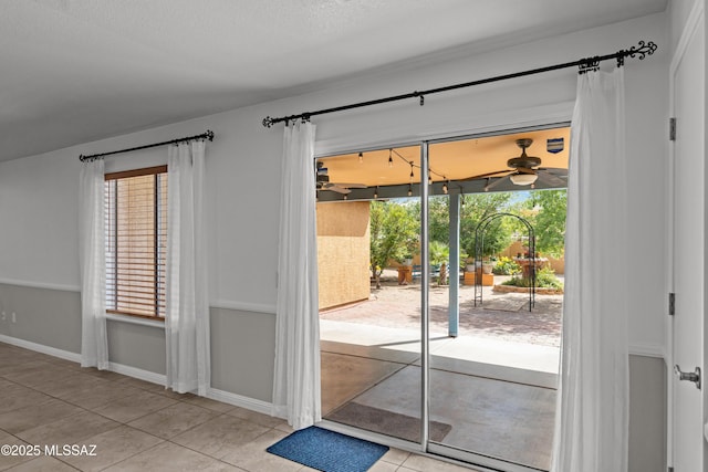 6945 S Wingbow Dr, Tucson, AZ 85756 - doorway to outside with ceiling fan, tile patterned floors, and baseboards