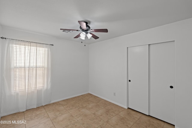 6945 S Wingbow Dr, Tucson, AZ 85756 - unfurnished bedroom featuring a closet, a ceiling fan, and baseboards